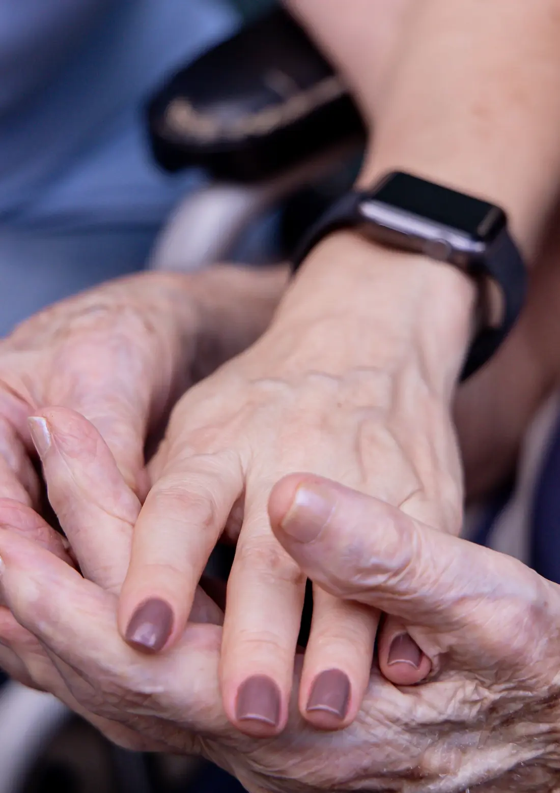 Eine Pflegekraft hält die Hand einer älteren Person